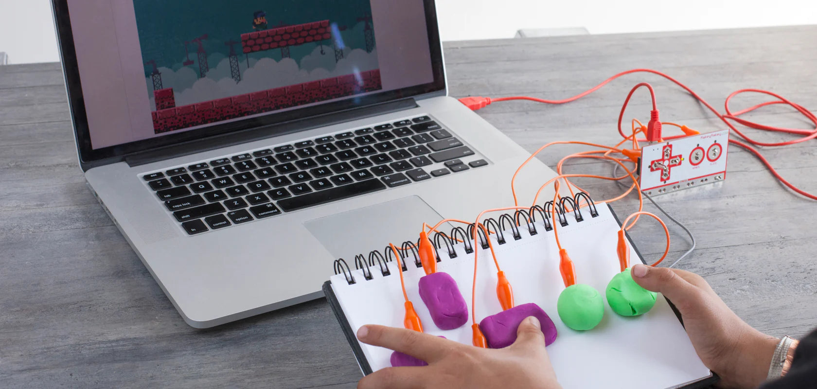 Makey Makey device wired to Play-Doh in the shape of a controller